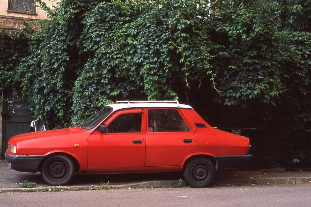Czerwona Dacia 1310 zaparkowana przy drodze w Bukaresz